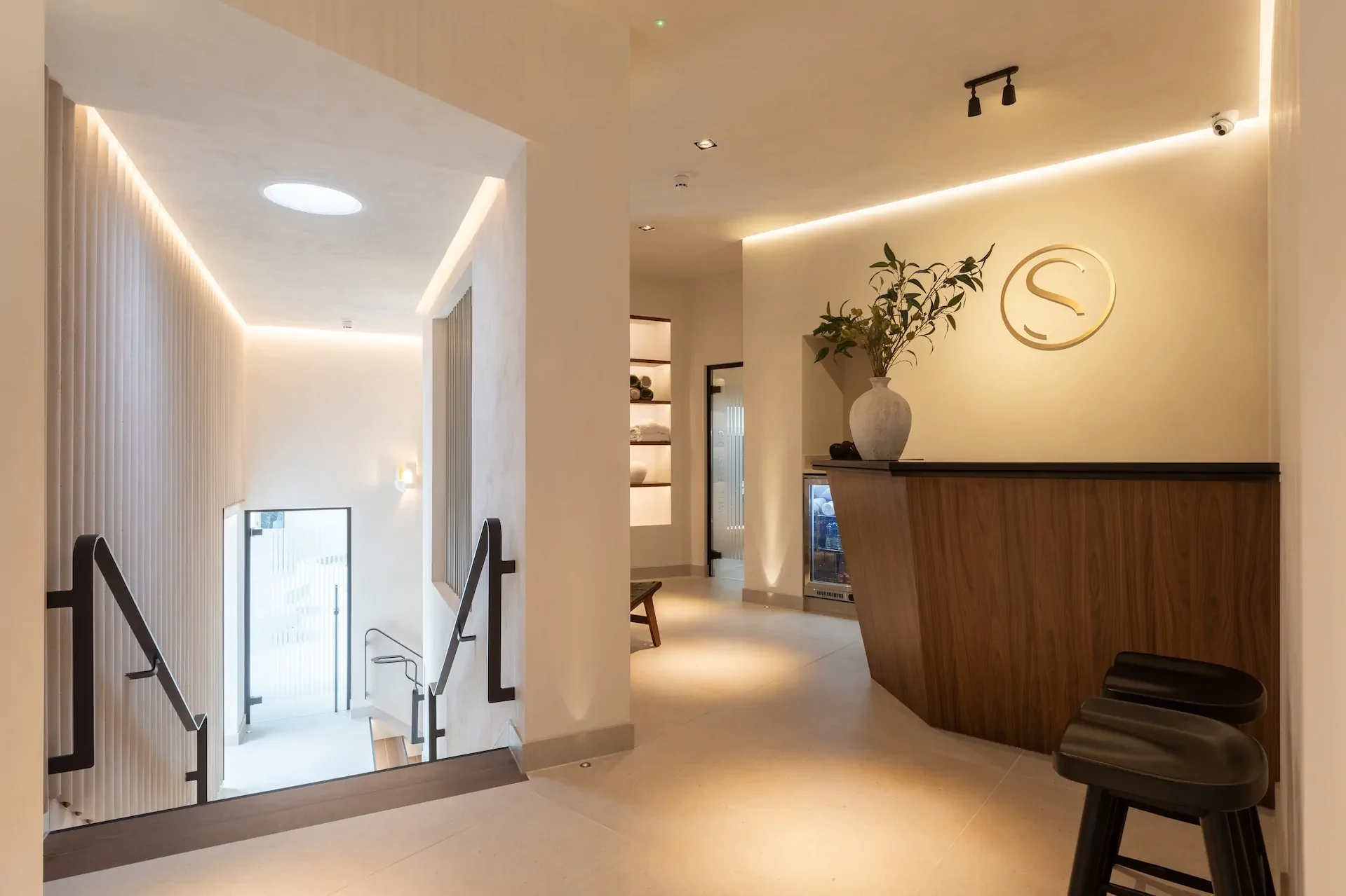 Elegant reception area with warm wood desk, ambient lighting, and modern architectural details
